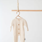 Jakopina Cable Knit Baby Romper in cream organic cotton with classic cable pattern.