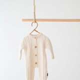 Jakopina Cable Knit Baby Romper in cream organic cotton with classic cable pattern.