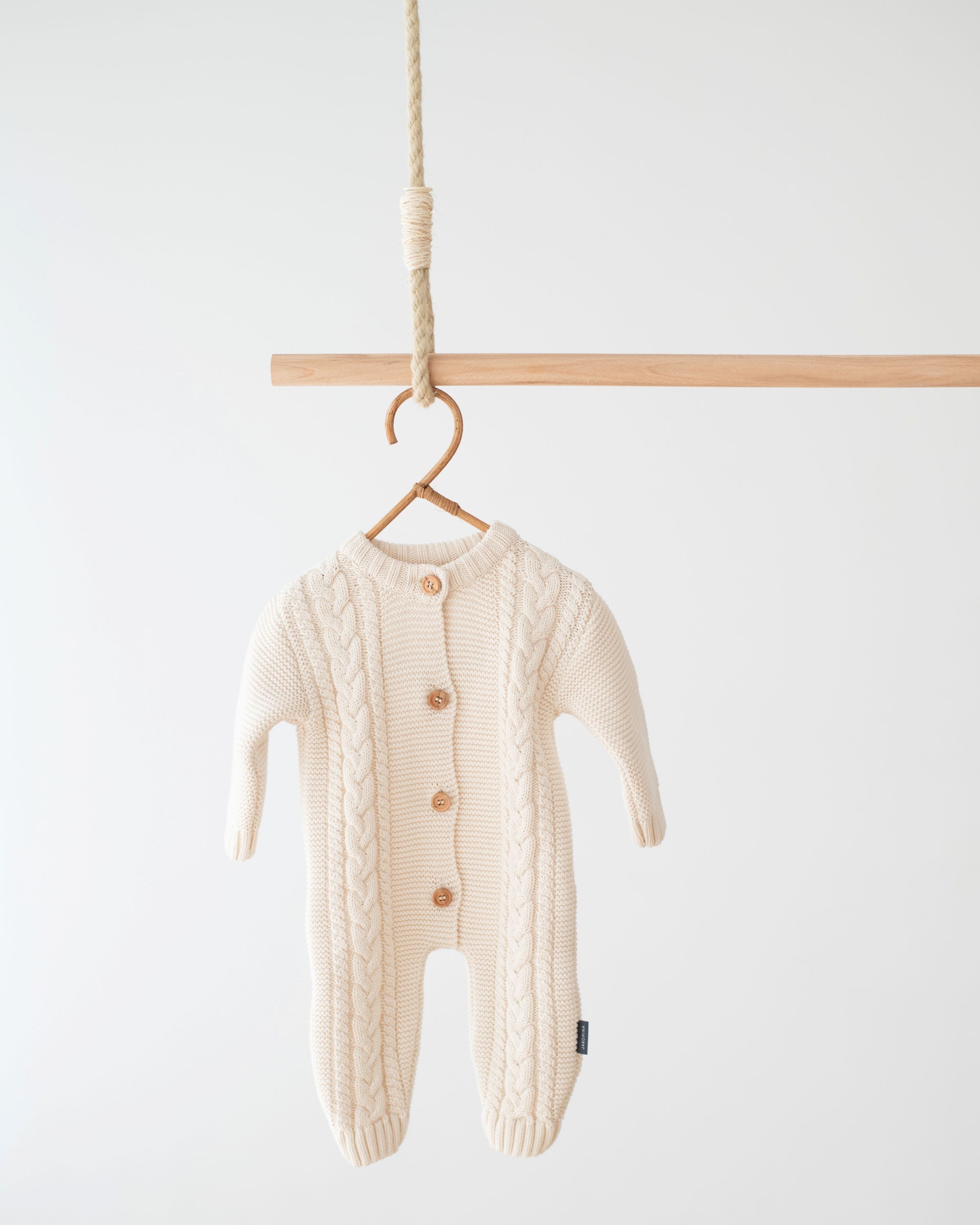 Jakopina Cable Knit Baby Romper in cream organic cotton with classic cable pattern.