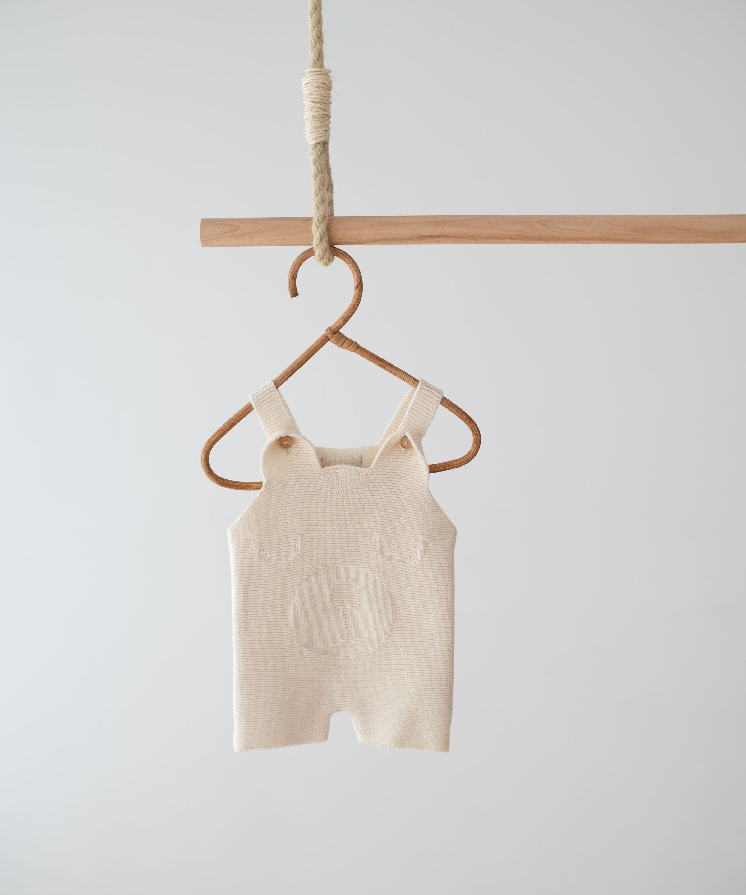Front view of the Jakopina Teddy Bear Romper Short in cream organic cotton with wooden buttons.